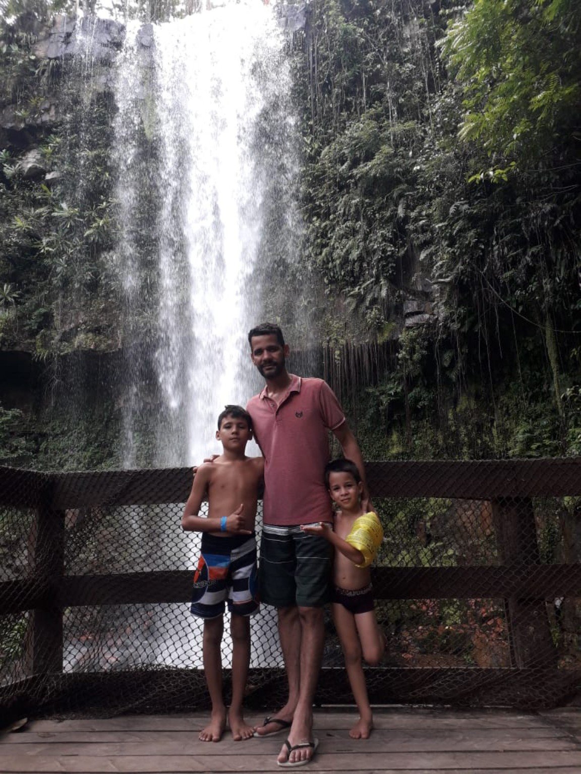 Rhuan com familiares em um momento especial diante de uma cachoeira
